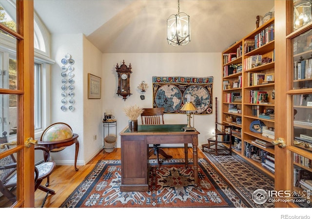 office with hardwood / wood-style flooring and a chandelier