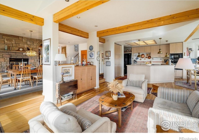 living room with light hardwood / wood-style flooring and beamed ceiling