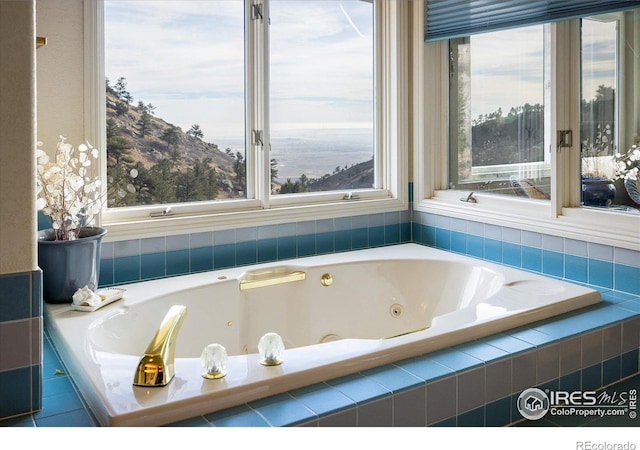 bathroom with tiled bath and a mountain view