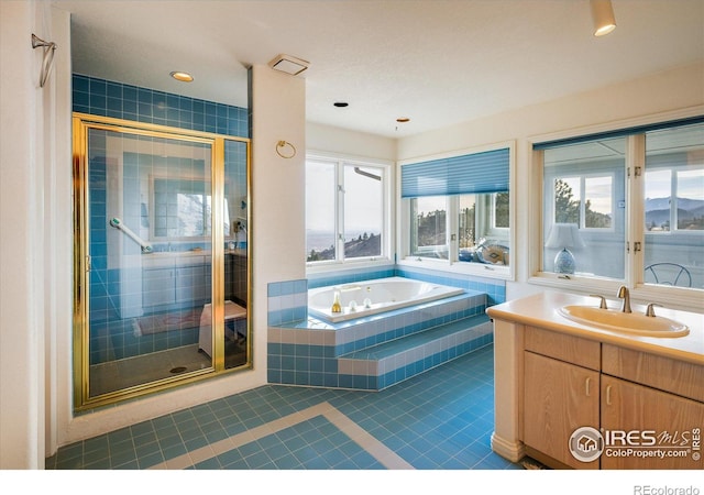 bathroom featuring tile patterned flooring, vanity, and shower with separate bathtub