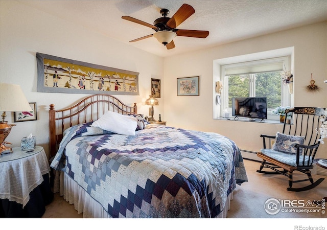 carpeted bedroom featuring ceiling fan and a textured ceiling