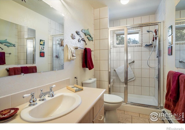 bathroom with tile patterned floors, vanity, toilet, and a shower with shower door