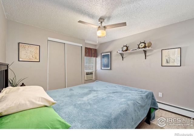 bedroom with ceiling fan, baseboard heating, cooling unit, a textured ceiling, and a closet