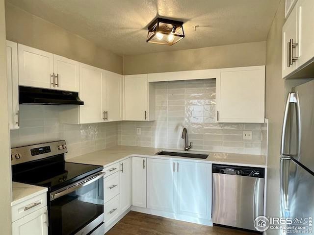 kitchen featuring white cabinets, appliances with stainless steel finishes, tasteful backsplash, and sink