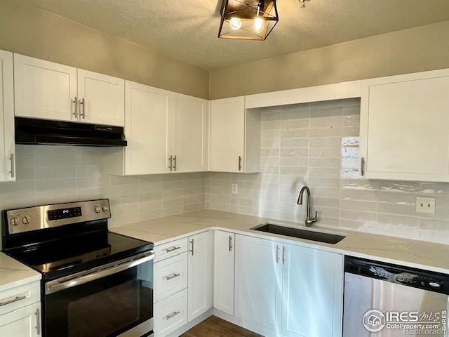 kitchen with tasteful backsplash, sink, white cabinets, and stainless steel appliances