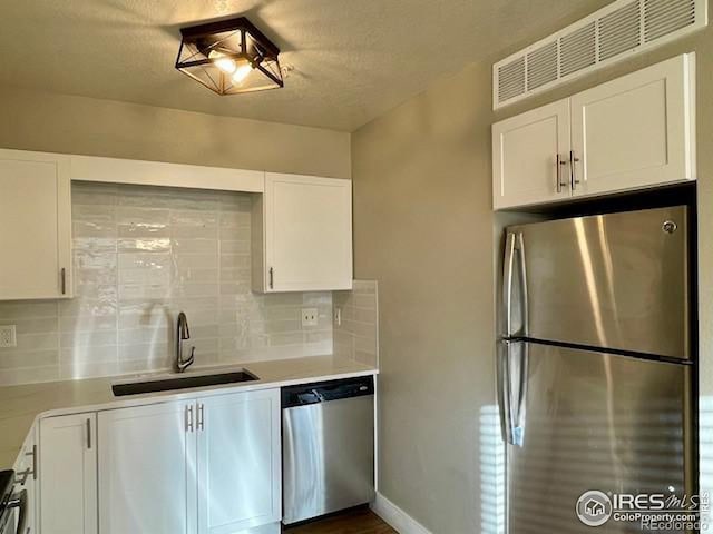 kitchen featuring backsplash, sink, white cabinets, and stainless steel appliances