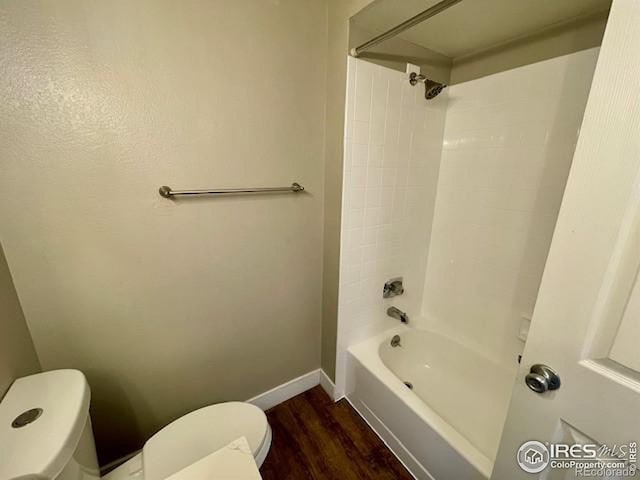 bathroom with hardwood / wood-style floors, shower / bathtub combination, and toilet