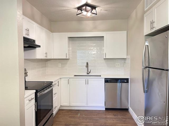 5540 Stonewall Pl Unit 16, Boulder, CO 80303 - kitchen featuring stainless steel appliances, under cabinet range hood, light countertops, and dark wood finished floors