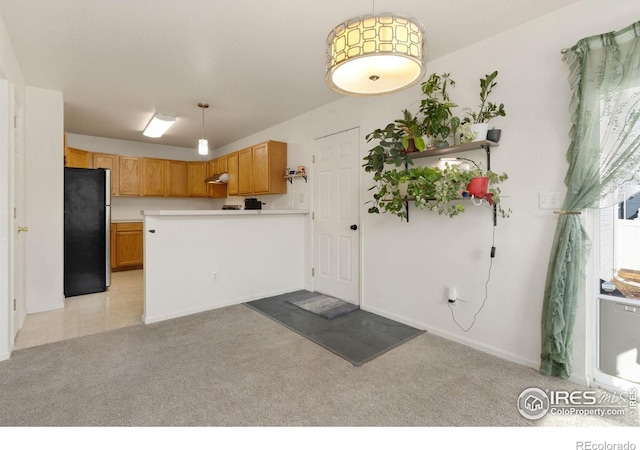 kitchen featuring kitchen peninsula, stainless steel fridge, light carpet, and decorative light fixtures