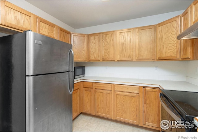 kitchen featuring stainless steel fridge, black electric range, and range hood