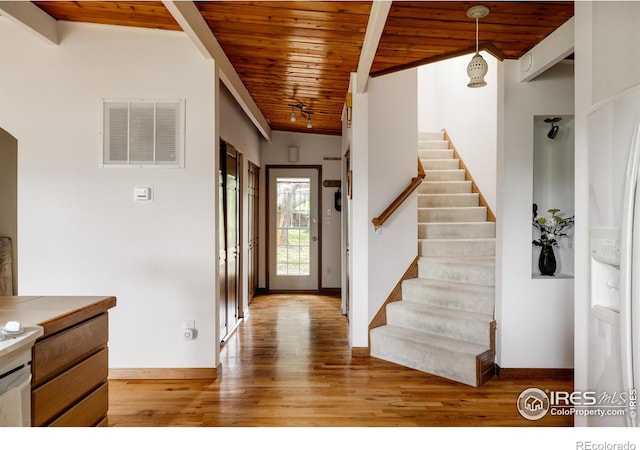 foyer entrance featuring light wood-type flooring and wood ceiling