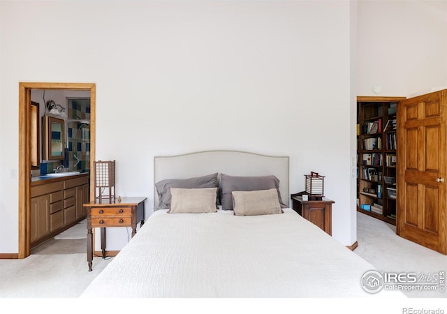 bedroom with light colored carpet and sink