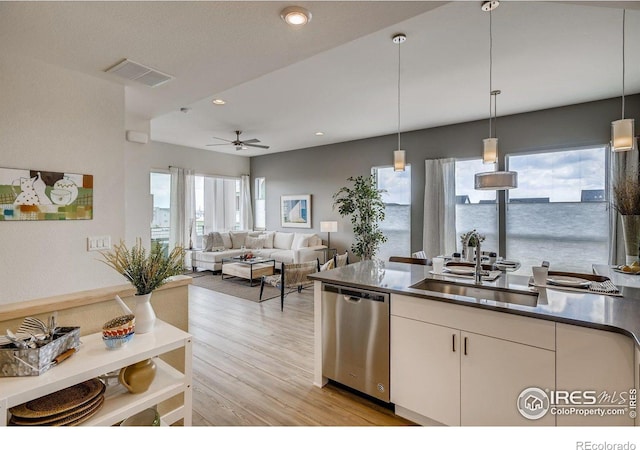 kitchen with plenty of natural light, sink, dishwasher, white cabinetry, and hanging light fixtures