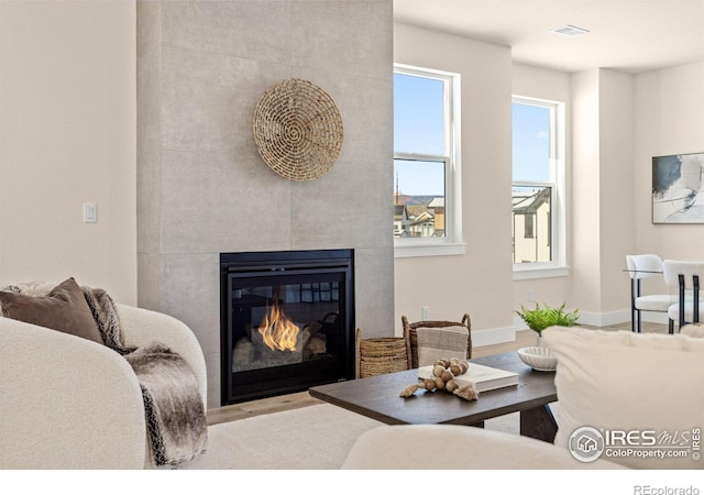 living room featuring a fireplace, light wood-type flooring, and plenty of natural light