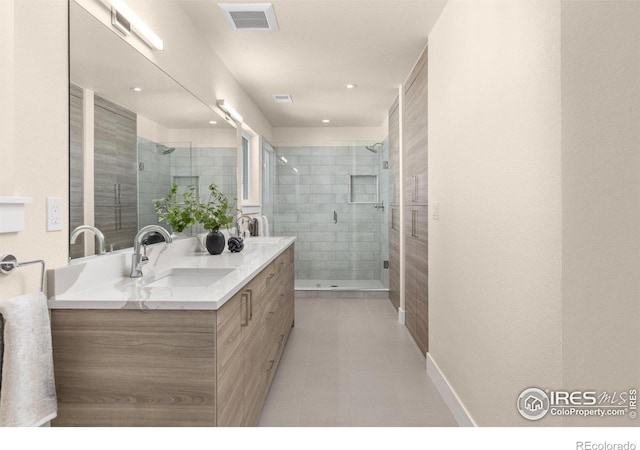 bathroom featuring a shower with door and vanity