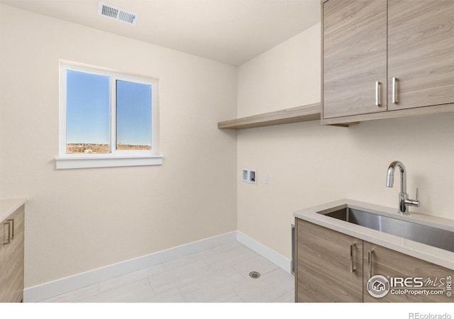 washroom featuring cabinets, sink, and hookup for a washing machine