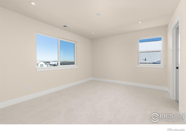 carpeted spare room featuring plenty of natural light