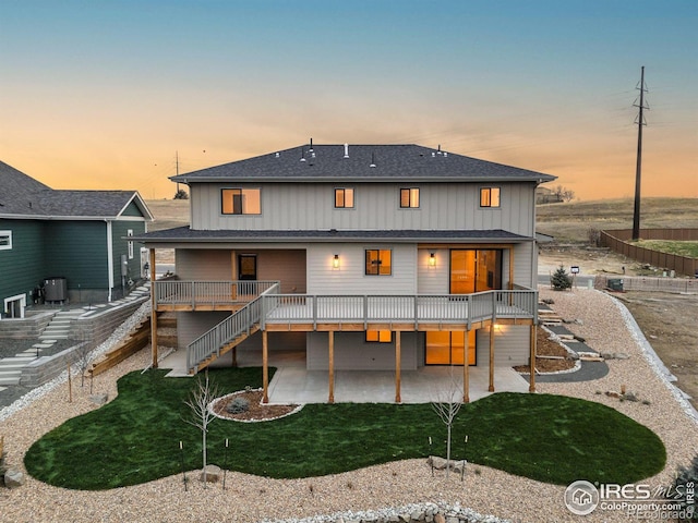 back house at dusk with a patio and a deck