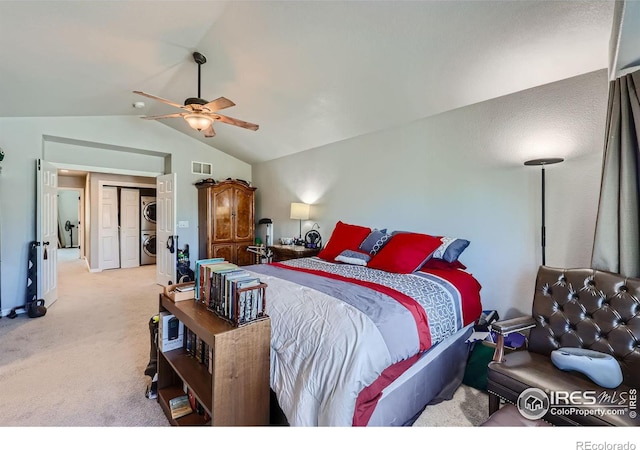 bedroom featuring ceiling fan, light colored carpet, stacked washer and dryer, and vaulted ceiling