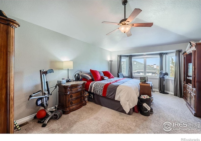 carpeted bedroom featuring a textured ceiling and ceiling fan