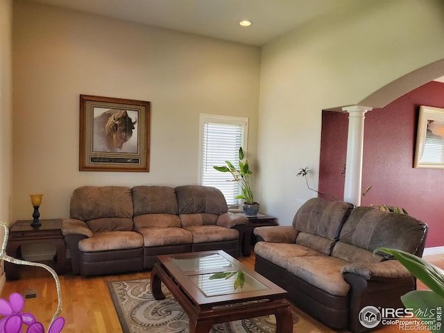 living room with decorative columns and light hardwood / wood-style floors