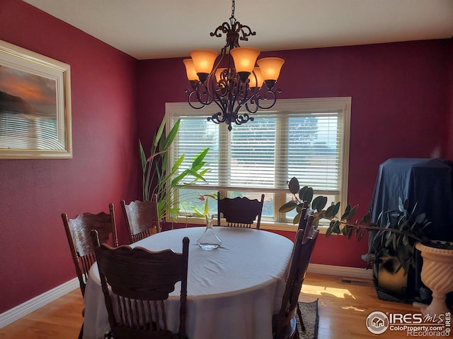 dining room featuring an inviting chandelier and light wood-type flooring