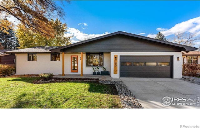 single story home featuring covered porch, a garage, and a front yard