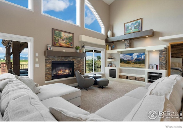 living room featuring a fireplace, a high ceiling, and built in features