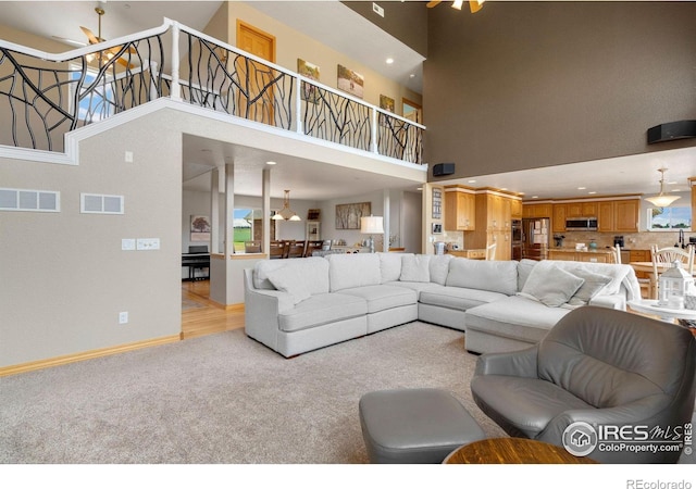 carpeted living room with a high ceiling