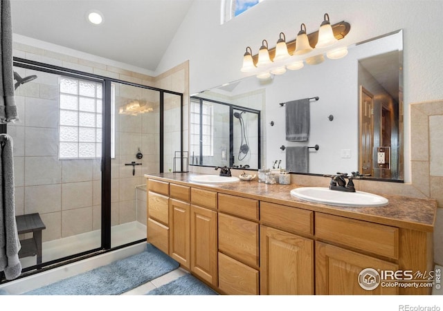 bathroom with tile patterned flooring, lofted ceiling, a shower with shower door, and vanity