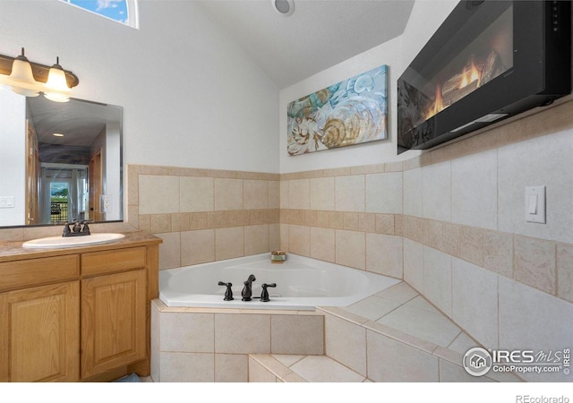 bathroom with vanity and a relaxing tiled tub