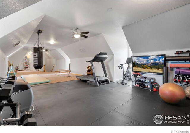 workout room featuring a textured ceiling, ceiling fan, and lofted ceiling