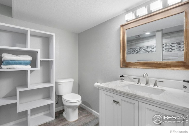 bathroom featuring vanity, hardwood / wood-style floors, a textured ceiling, and toilet