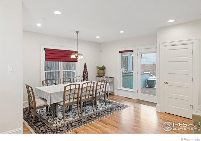 dining area featuring hardwood / wood-style floors and an inviting chandelier