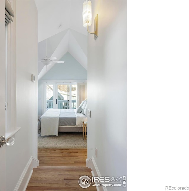 bedroom featuring light hardwood / wood-style floors, vaulted ceiling, and ceiling fan