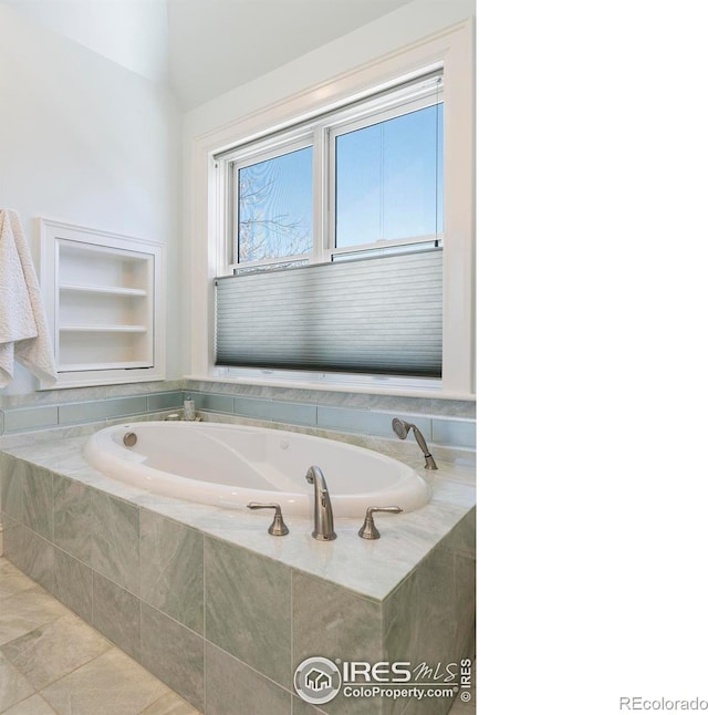 bathroom featuring tile patterned floors, built in features, tiled bath, and vaulted ceiling