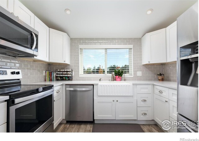 kitchen featuring backsplash, sink, white cabinetry, and stainless steel appliances