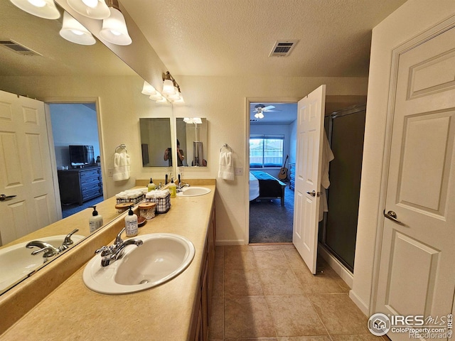 bathroom featuring a textured ceiling, ceiling fan, walk in shower, and vanity