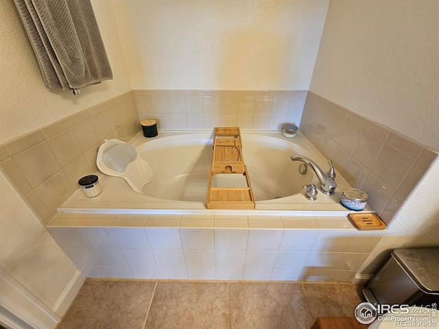 bathroom with tile patterned floors and a relaxing tiled tub