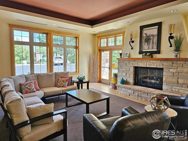 living room with tile patterned flooring, a fireplace, and a tray ceiling