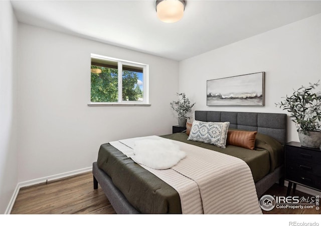 bedroom featuring baseboards and wood finished floors