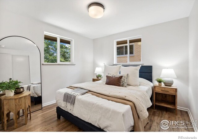 bedroom with wood finished floors and baseboards