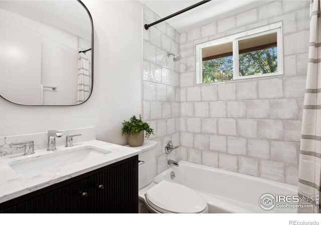 full bathroom with shower / tub combo with curtain, vanity, and toilet