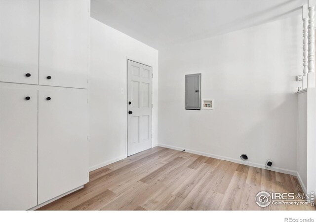 washroom with hookup for a washing machine, light wood-style flooring, electric dryer hookup, electric panel, and baseboards