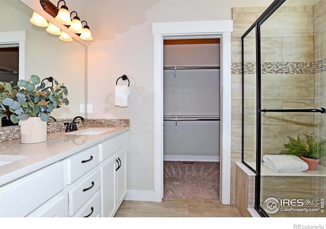 bathroom with vanity and a shower with door