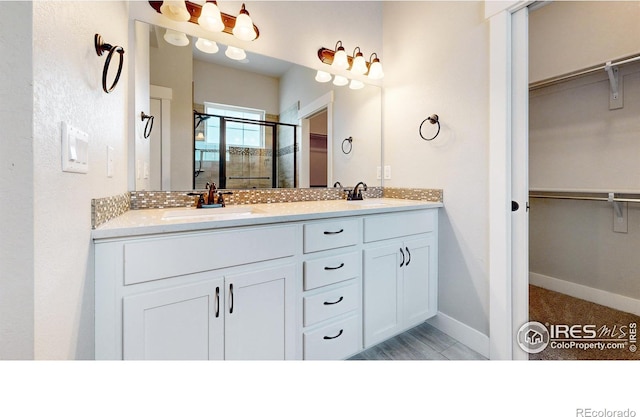 bathroom with vanity and a shower with shower door