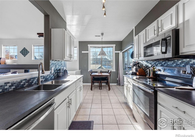 kitchen with tasteful backsplash, white cabinetry, sink, and appliances with stainless steel finishes