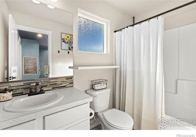 bathroom with vanity, toilet, and backsplash