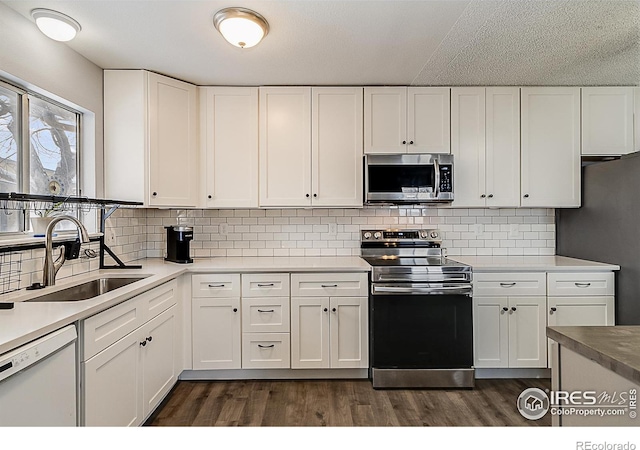 kitchen featuring a sink, dark wood finished floors, white cabinetry, and stainless steel appliances