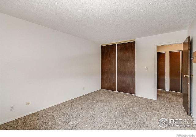 unfurnished bedroom featuring carpet, a closet, and a textured ceiling